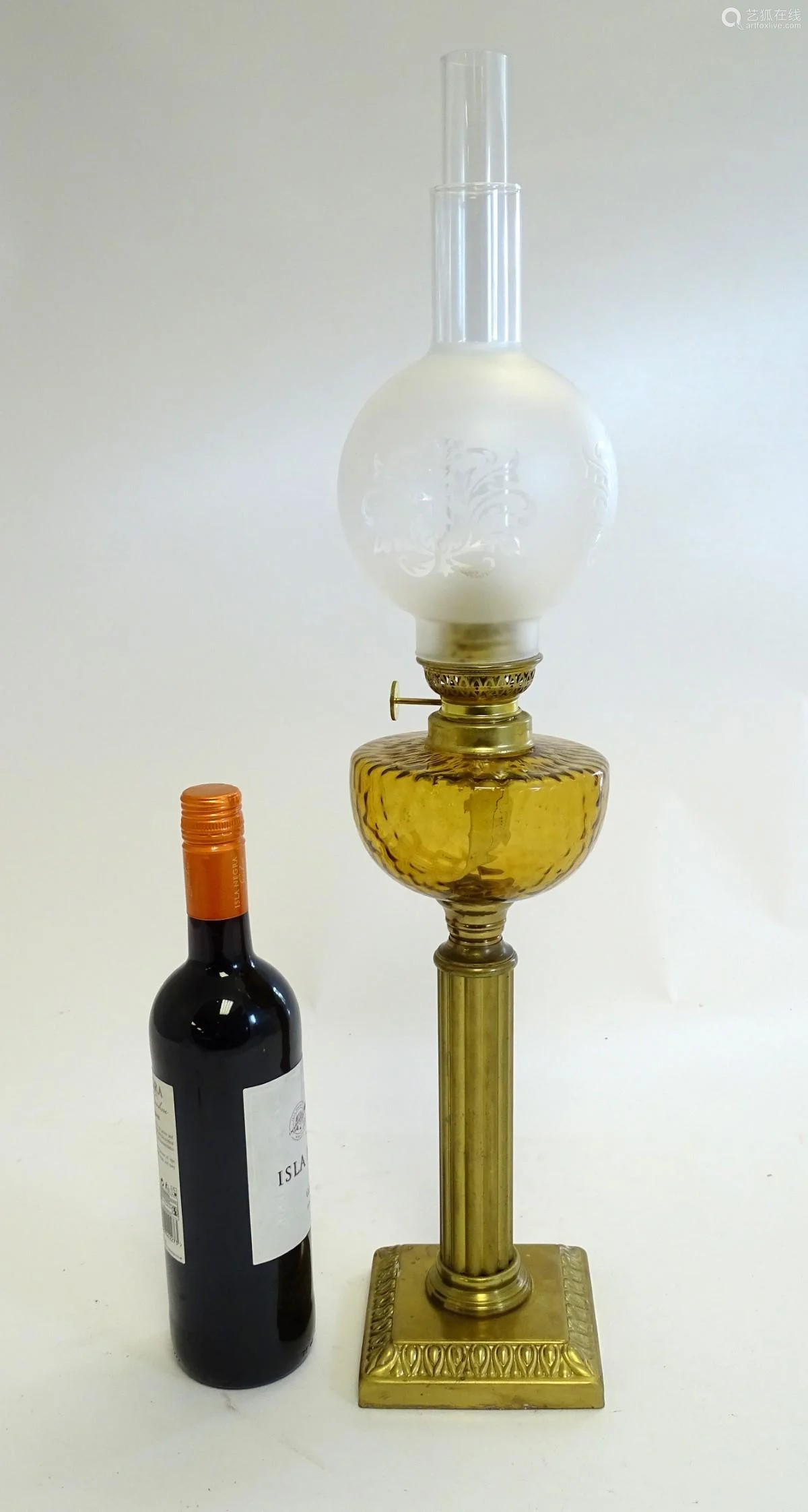 an oil lamp with brass square base supporting a col