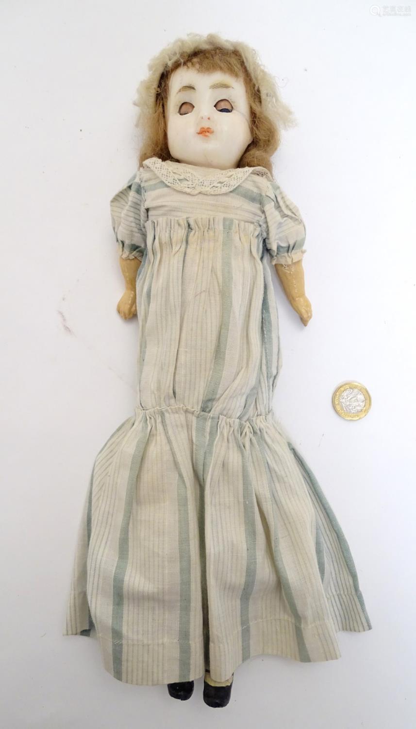 toy: a wax headed doll with blue eyes, painted features, brown