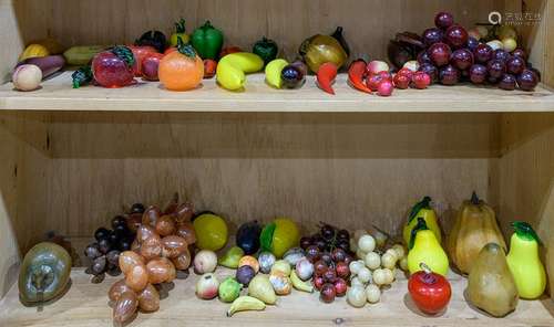 Two shelves of hardstone and glass fruits and