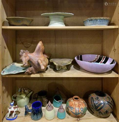 Three shelves of art pottery including a footed compote