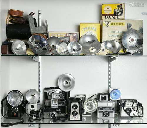 Two shelves of vintage flash cameras and equipment