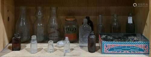 One shelf of vintage glass bottles in clear and brown,