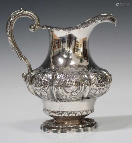 An early Victorian silver jug of baluster form, decorated in relief with foliate and scroll