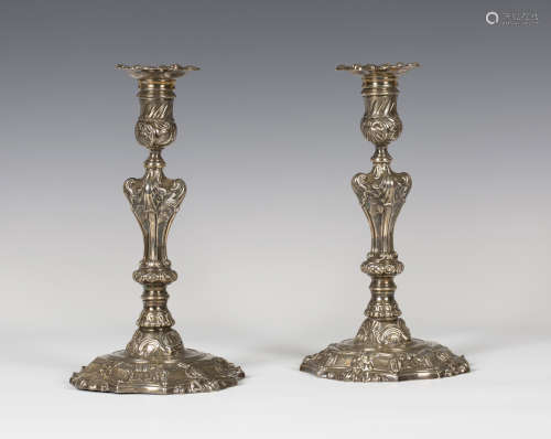 A pair of George II cast silver candlesticks, each with a detachable nozzle above a baluster stem,