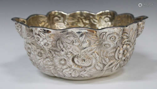 An American sterling silver punch bowl of circular lobed form, decorated in relief with daisies,