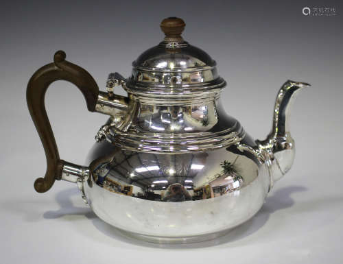 A George I style silver teapot of low-bellied circular form with hinged lid, London 1928 by