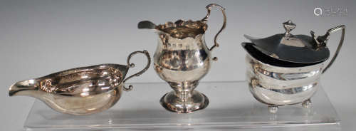 A George III silver cream jug of ogee baluster form with scroll handle, on a circular domed foot,