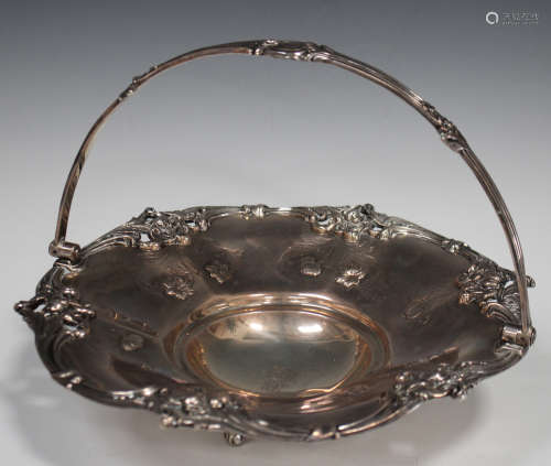 A William IV silver circular basket with cast and pierced foliate scroll rim and overhead swing