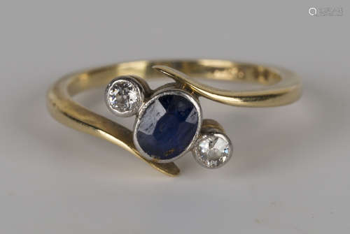 A gold, sapphire and diamond three stone ring, mounted with an oval cut sapphire between two cushion