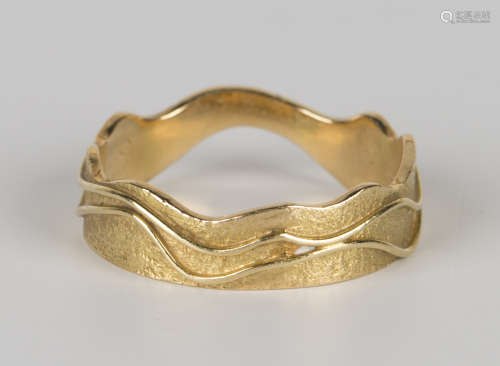 An 18ct gold wedding ring in an abstract design with a textured finish, ring size approx O.Buyer’s