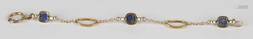A gold and lapis lazuli bracelet in an open oval and circular link design, mounted with three