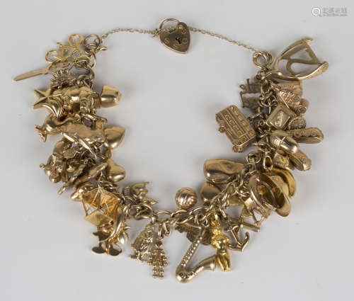 A 9ct gold curblink charm bracelet, fitted with approximately fifty-one charms, including a pig, a