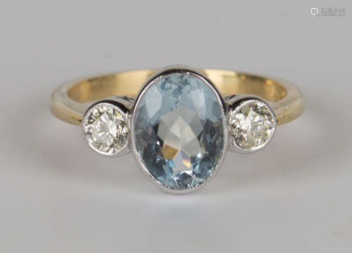A gold, aquamarine and diamond ring, collet set with an oval cut aquamarine between circular cut