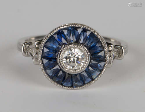 A platinum, sapphire and diamond ring, collet set with a circular cut diamond within a border of