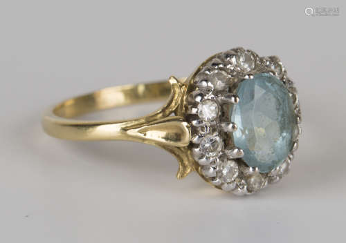 An aquamarine and diamond oval cluster ring, claw set with the oval cut aquamarine within a surround