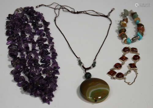 A three row necklace of amethyst quartz beads, a reconstituted amber bracelet, a vari-coloured