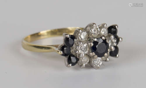 An 18ct gold, sapphire and diamond cluster ring, claw set with the principal circular cut sapphire