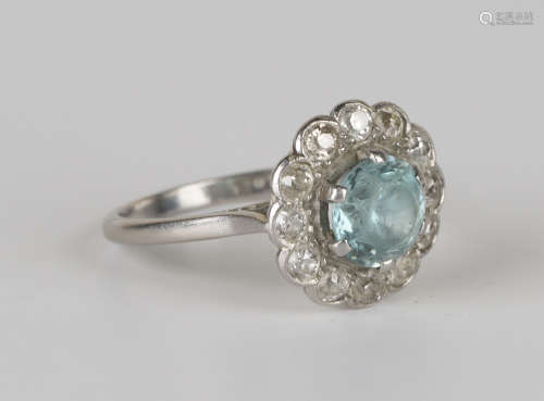 A platinum, blue zircon and diamond cluster ring, claw set with the circular cut blue zircon