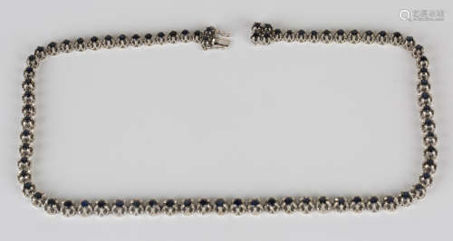 A white gold and sapphire necklace, mounted with a row of graduated circular cut sapphires, on a