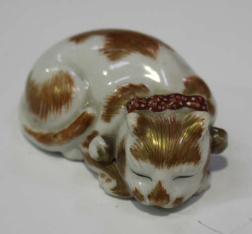 A Japanese Kutani porcelain netsuke, Meiji/Taisho period, modelled as a sleeping cat with iron red