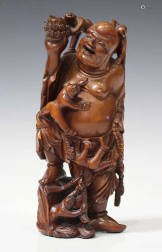 A Chinese carved boxwood figure group of a smiling Buddha, early 20th century, modelled standing and