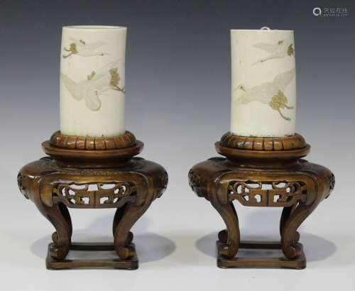 A pair of Japanese ivory tusk vases and wood stands, Meiji period, each tusk section incised and