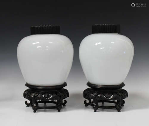 A pair of Chinese Peking white glass jars with hardwood covers and stands, Republic period, each
