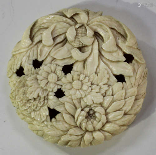 A Japanese carved and pierced ivory manju netsuke, Meiji period, finely carved with peonies and