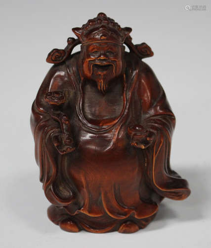 A Chinese carved boxwood figure of a god, 20th century, modelled standing wearing a long robe and