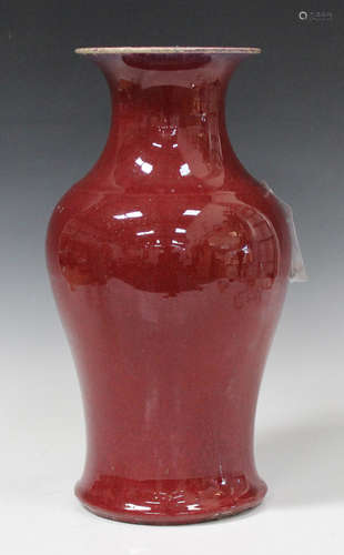 A Chinese sang-de-boeuf glazed porcelain vase, Qing dynasty, of baluster form with flared neck,