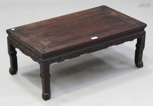 A Chinese hardwood low table, late 19th century, the rectangular panelled top above an archaistic