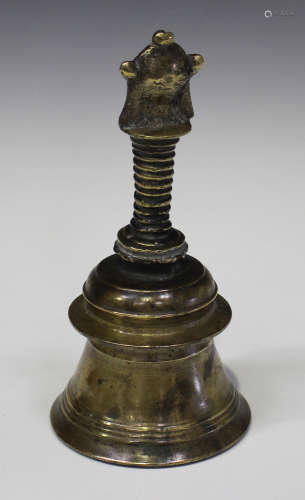 An Indian bronze temple bell, probably 20th century, the turned body with ribbed handle, height