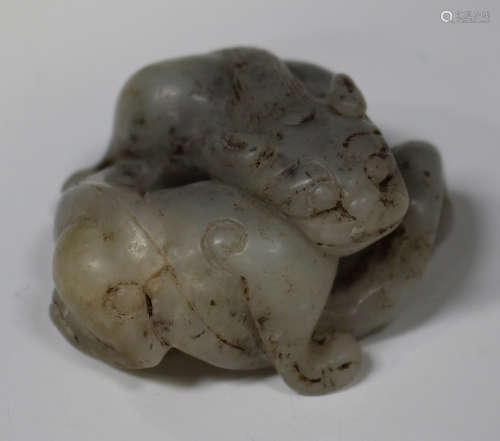 A Chinese carved and pierced jade figure of a chiling, 20th century, modelled in a curled pose,