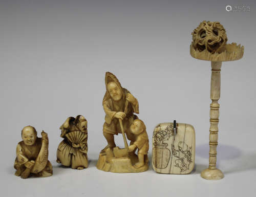 A Japanese carved and pierced ivory okimono figure group of a father and son, Meiji period, the