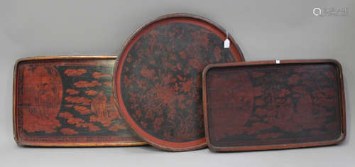 Three Japanese black and dark red lacquered trays, early 20th century, comprising two rectangular,