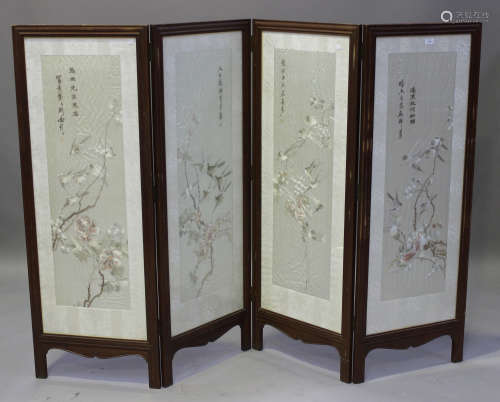 A Chinese hardwood and silk embroidered four-fold screen, late Qing dynasty, each glazed panel
