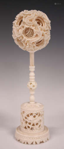 A Chinese Canton export ivory puzzle ball and stand, late Qing dynasty, the outer case carved in
