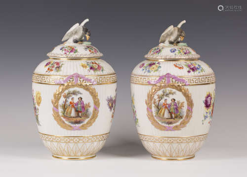 A pair of Berlin porcelain vases and covers, 19th century, each fluted ovoid body painted with