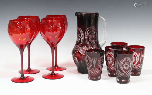 A collection of mostly red tinted glassware, including a Bohemian ruby flash overlay cut jug and