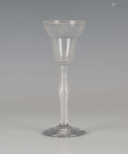 An airtwist stem wine glass, mid-18th century, the pan-topped rounded funnel bowl engraved with a