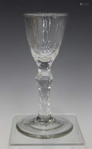 A faceted stem wine glass, late 18th century, the rounded funnel bowl with faceted base, raised on a