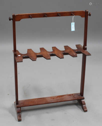 A 19th century mahogany boot stand, the top rail fitted with riding crop pegs above a central boot