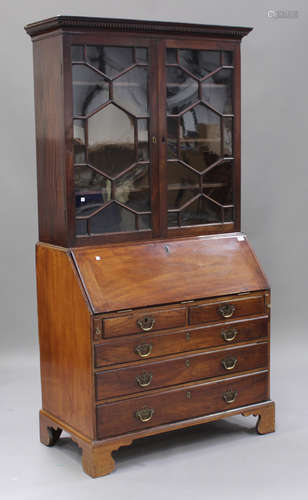 A George III mahogany bureau bookcase, the dentil moulded pediment above a pair of astragal glazed