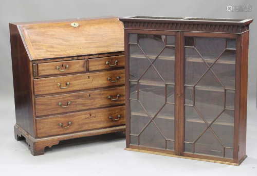 A George III mahogany bureau with an associated bookcase top, the fall front revealing a fitted