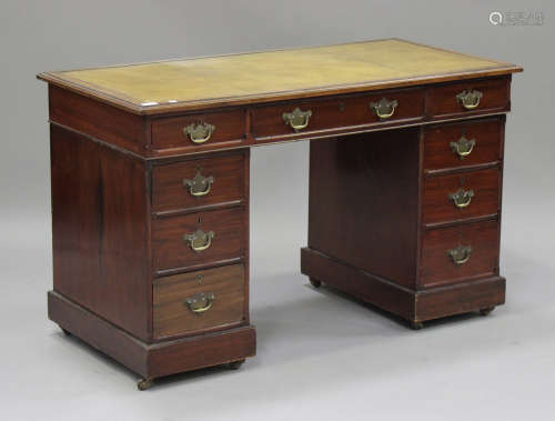 A late Victorian mahogany twin pedestal desk, the top inset with a gilt-tooled green leather writing