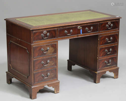 A late 20th century mahogany twin-pedestal desk, the green leather top above an arrangement of