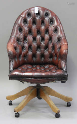 A 20th century reproduction red buttoned leather revolving office chair, raised on outswept legs and