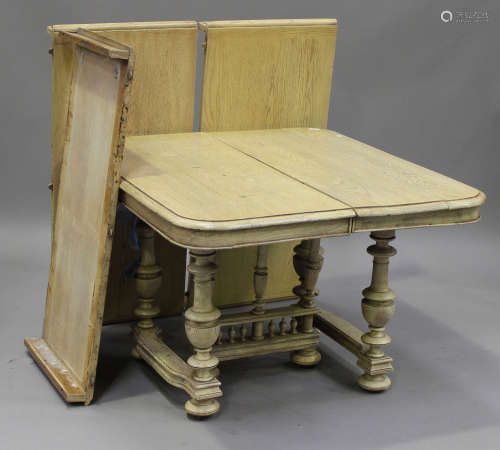 A late 19th century French bleached oak extending dining table with three extra leaves, raised on