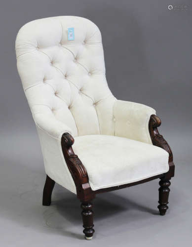 A Victorian mahogany framed armchair with carved decoration, upholstered in cream velour, on