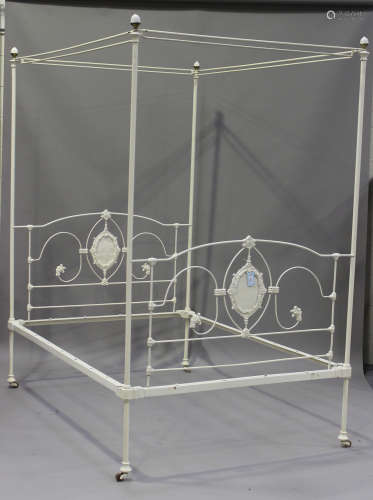 A late 19th century cream painted double tester bed frame with cast foliate scroll decoration, the